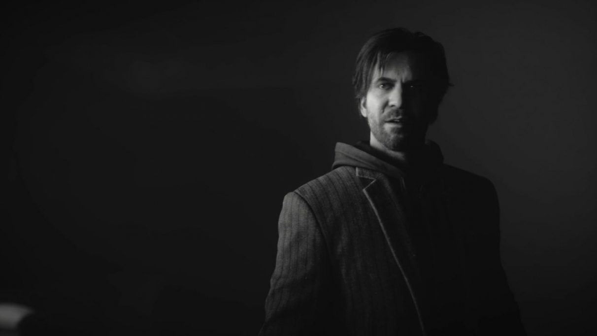 A screenshot from Control's AWE DLC showing Alan Wake, a tired looking bearded man in his mid to late 30s. He is wearing a suit jacket over a blazer, like a fool.