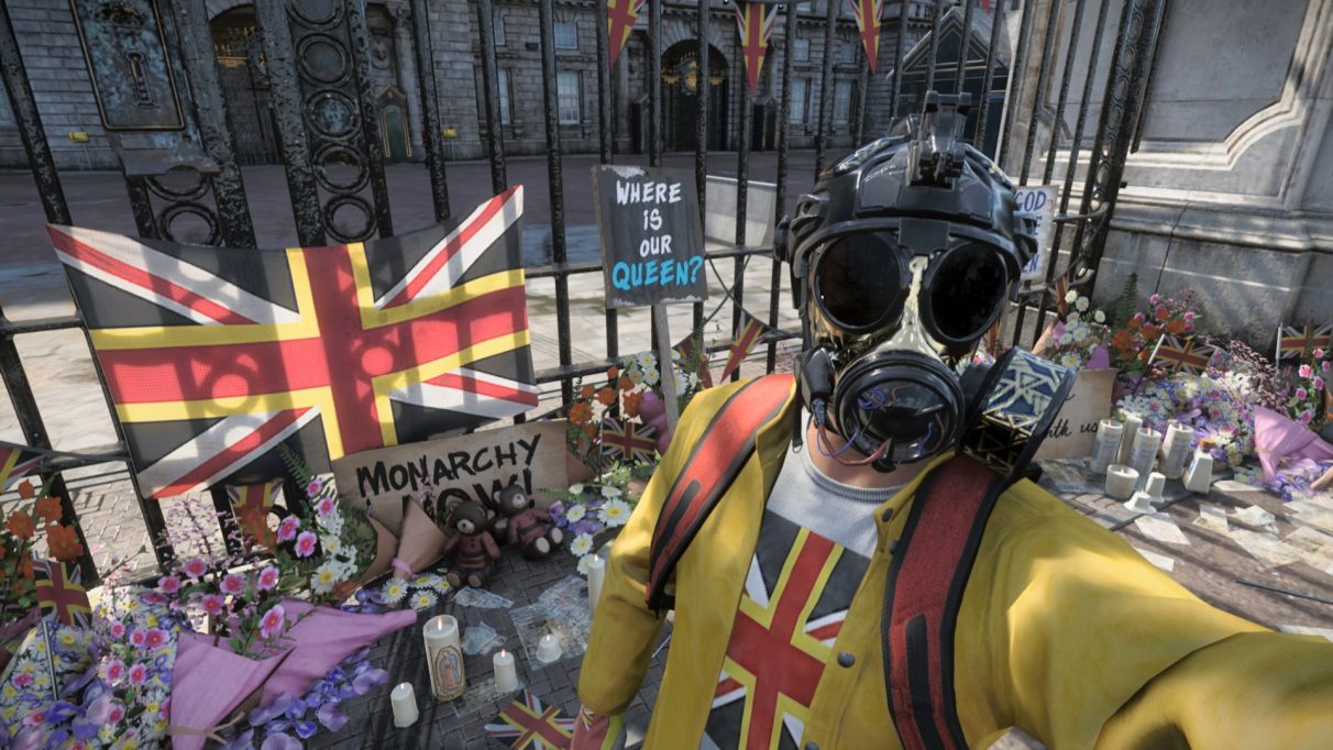 Ronald takes a selfie wearing a tricked-out cyberpunk gas mask, in front of loads of memorial flowers for the queen