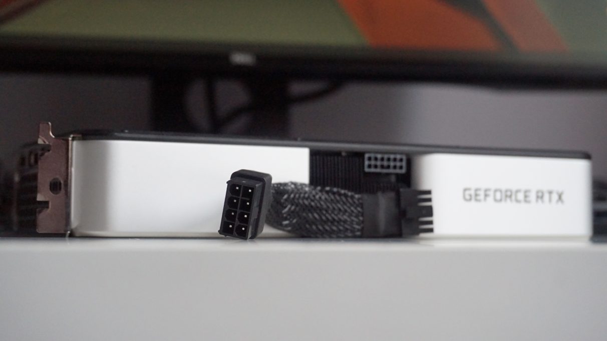 A photo of the Nvidia GeForce RTX 3060 Ti Founders Edition and its 8-pin to 12-pin power connector adapter.