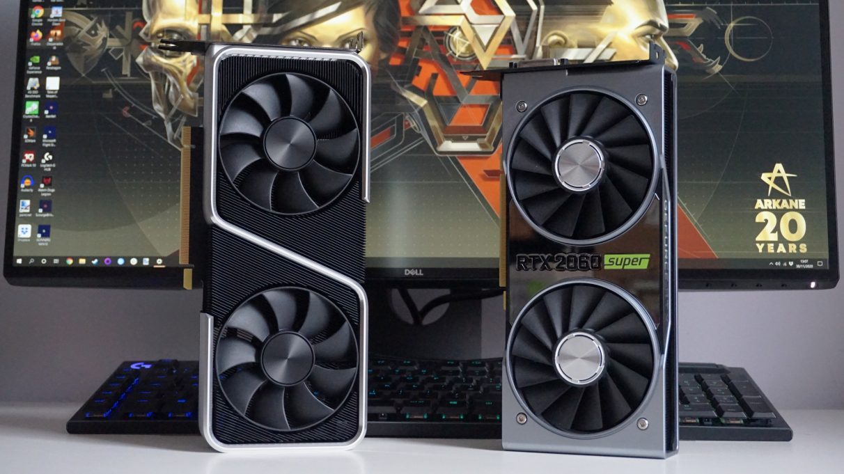 A photo showing the Nvidia GeForce RTX 3060 Ti Founders Edition standing upright next to the RTX 2060 Super Founders Edition in front of a monitor and keyboard.