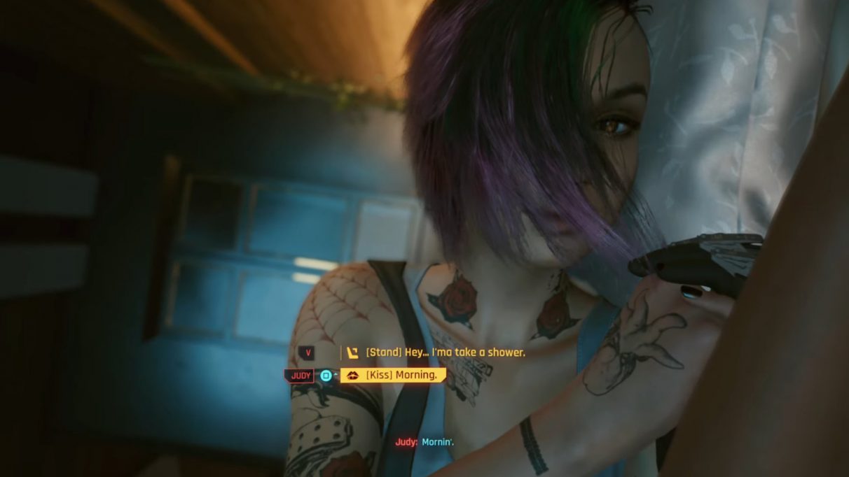 A screenshot of Judy Alvarez in Cyberpunk 2077, waking up next to the player character, V.