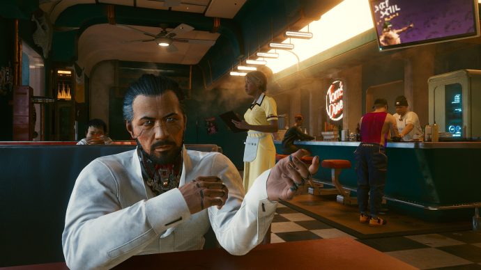 A screenshot of the inside of a diner in Cyberpunk 2077, in which the player is in conversation with Takemura, a Japanese man who is gesturing while he speaks.